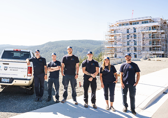 team of 6 standing with mountain range in distance